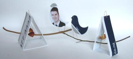 Bird feeders made out of a Harcourts real estate sign.